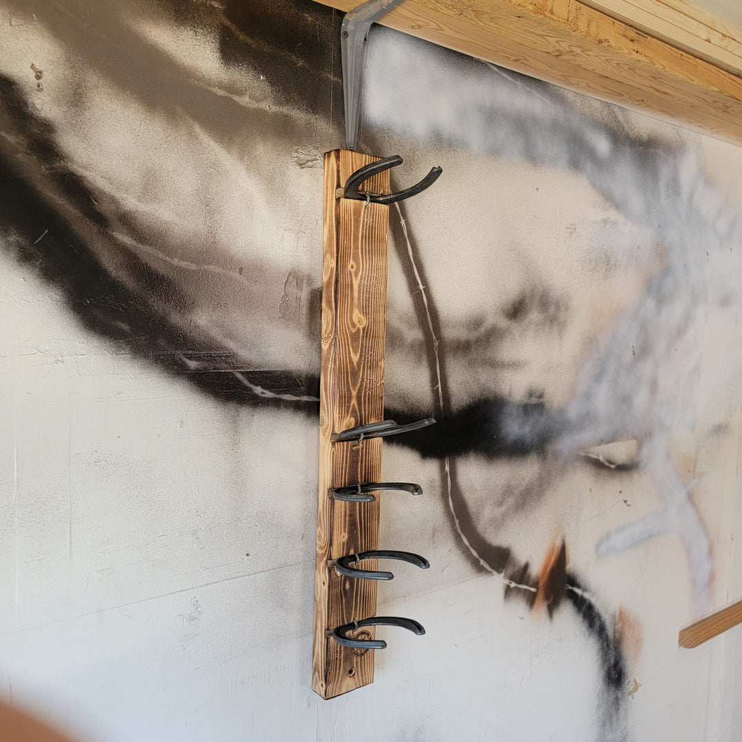 Wood wall rack with several metal hooks for hanging motorcycle gear