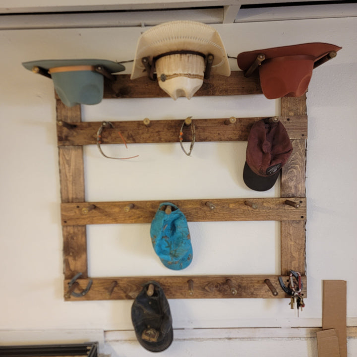 Wooden hat rack with several caps: cream, rust, burgundy, blue, and dark gray