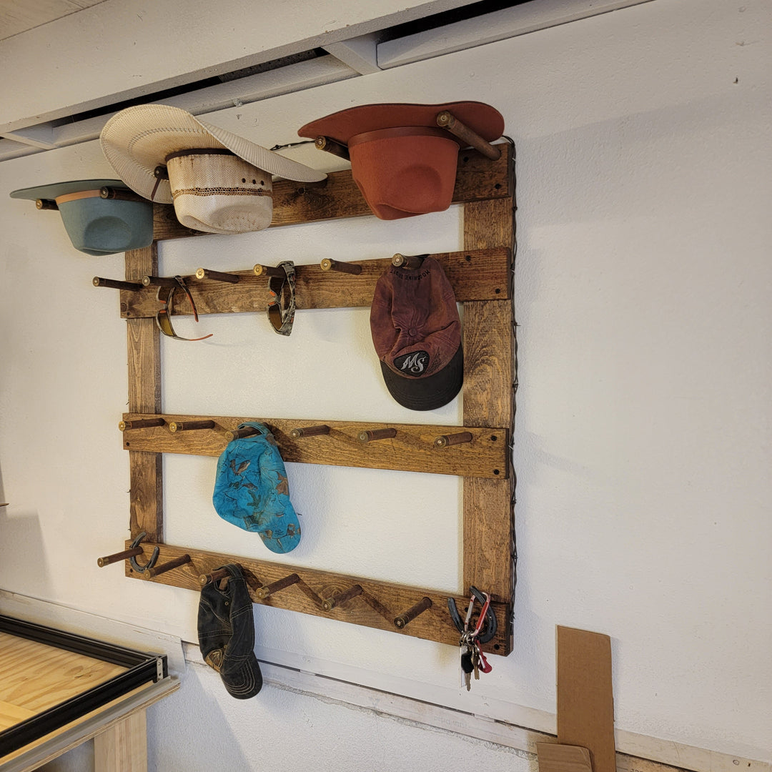 Wooden hat rack with mounted cowboy and ball caps in beige, blue, and dark tones