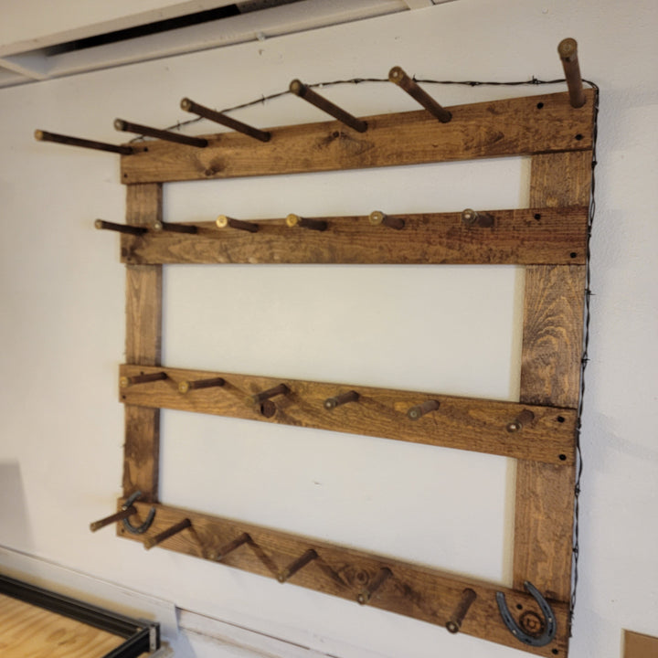 Wooden wall hat rack with horizontal bars and rows of metal hat hooks