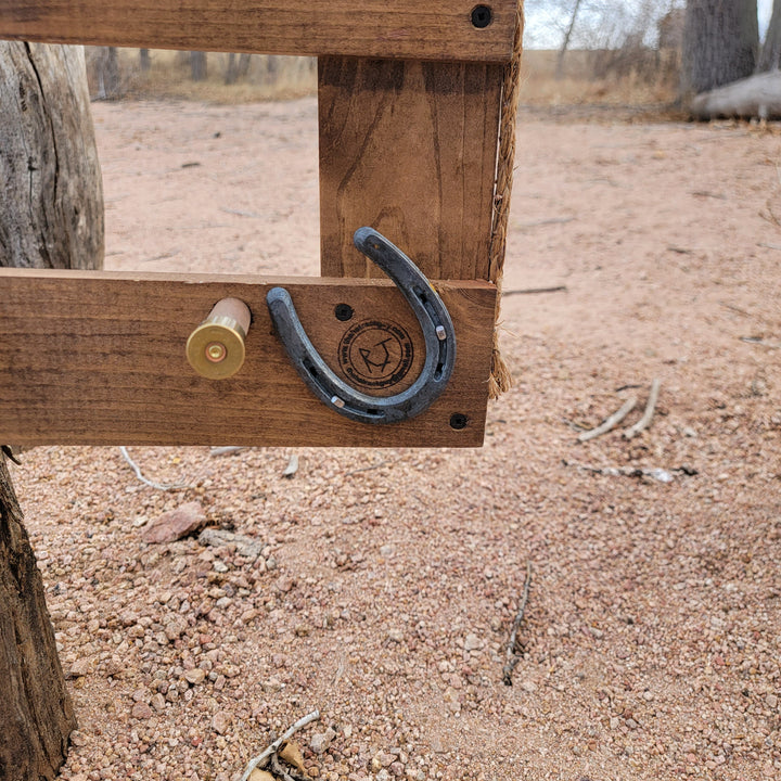Wooden corner of a wall-hanging hat organizer with horseshoe hook and fasteners