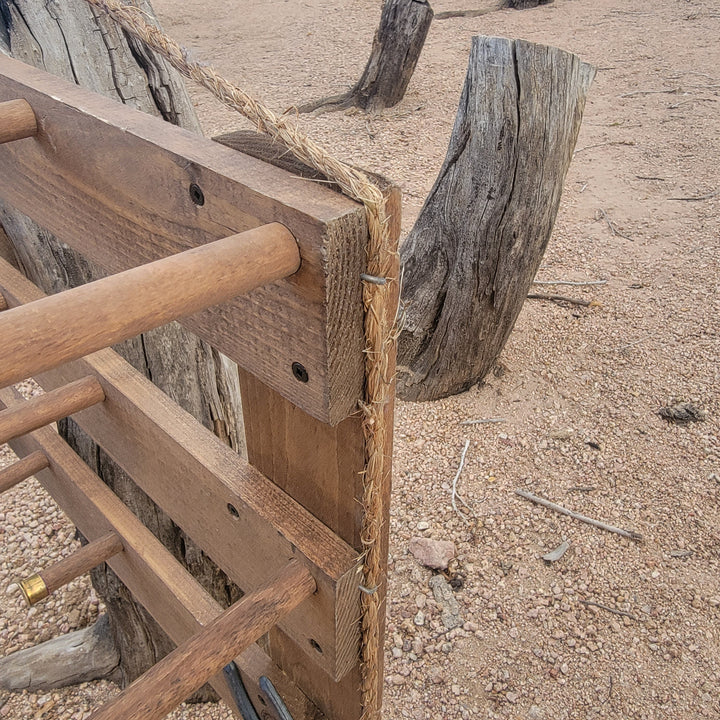 Wood and rope tie details on a wall-hanging hat organizer with horseshoe hook