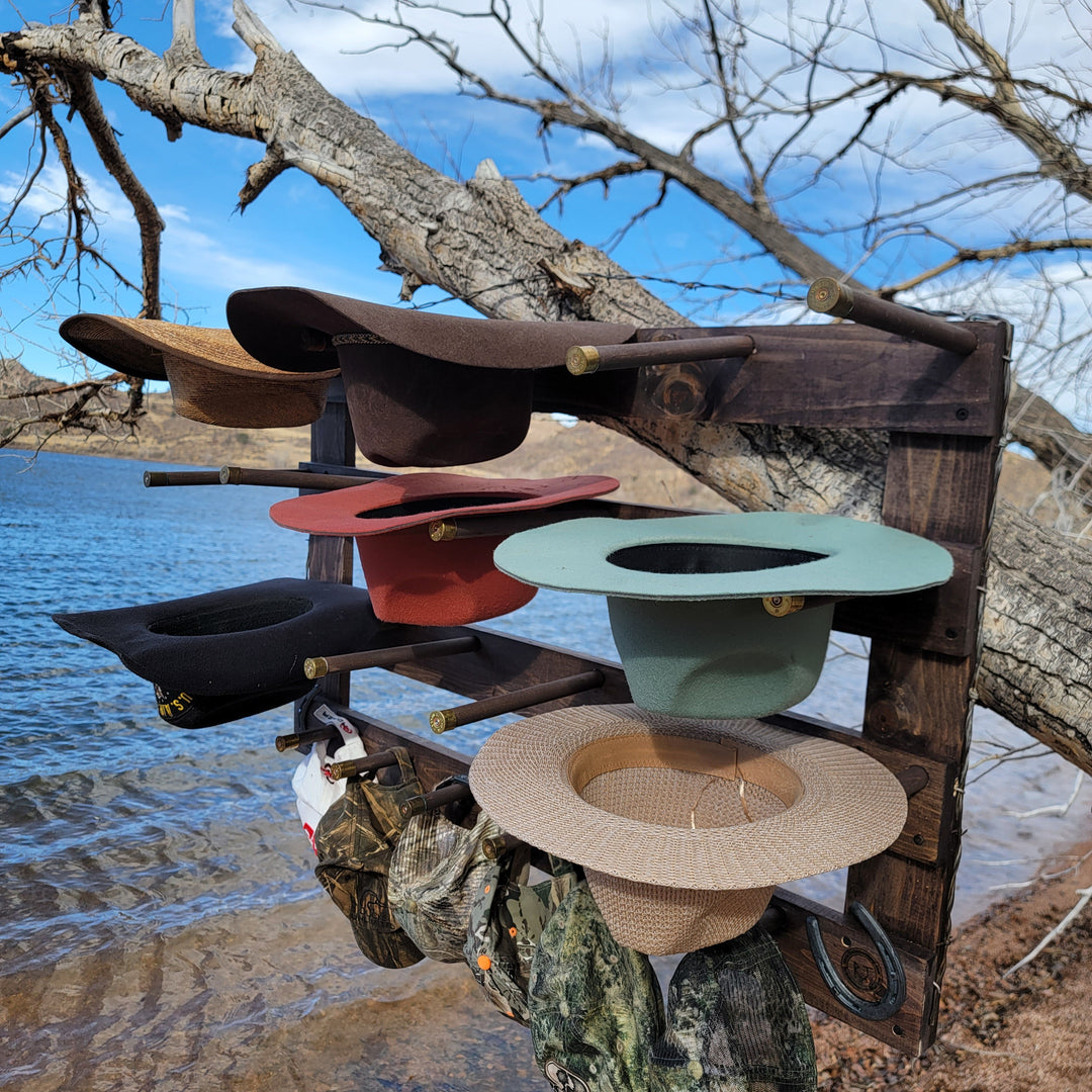 Wall-hanging hat organizer with multiple hats in dark, red, and green tones on pegs
