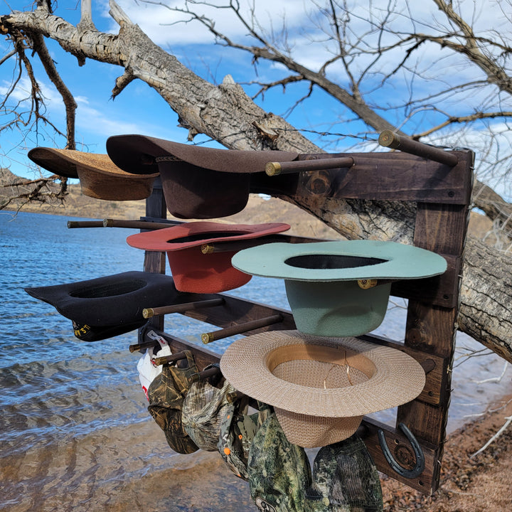 Wall-hanging hat organizer with multiple hats in dark, red, and green tones on pegs