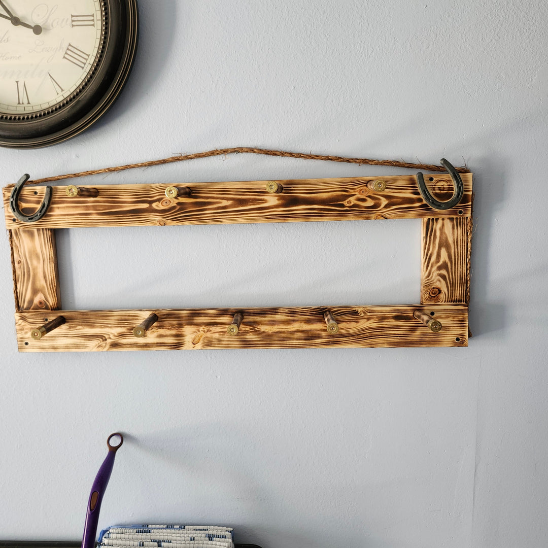 Wall-mounted coat rack with rustic wooden frame and several hook points