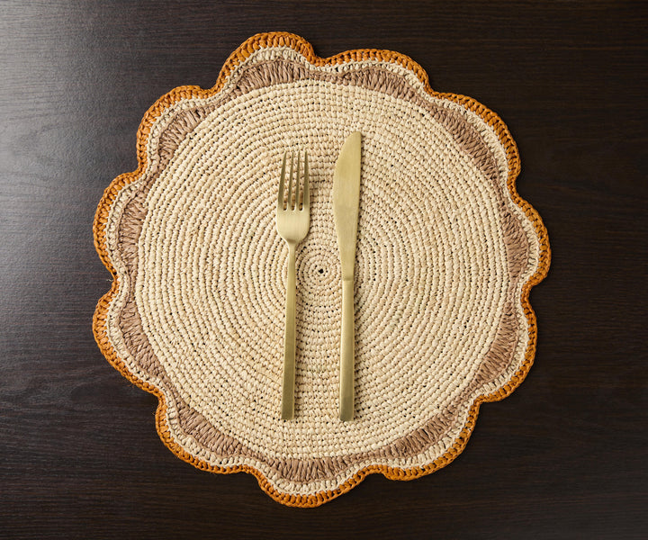 A handwoven Raffia Placemat in Tan, Orange & Brown
