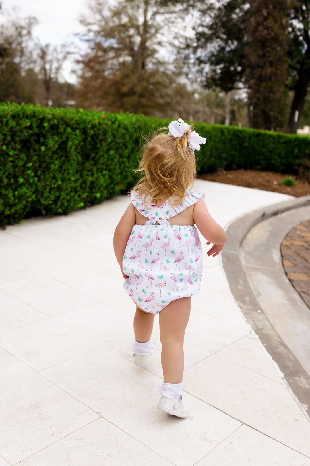 Pink and white flamingo-print bubble romper with flutter sleeves and snap legs