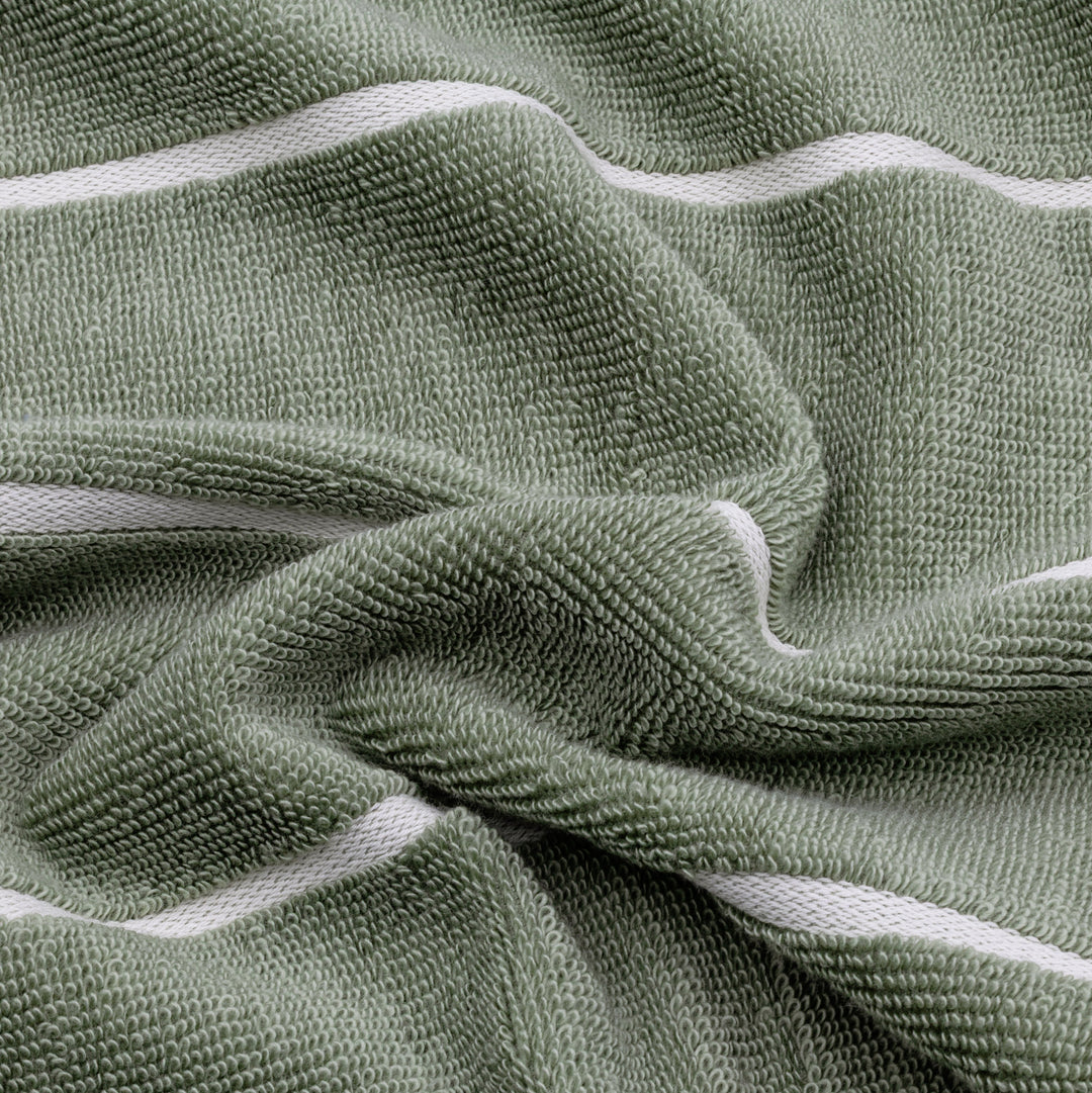 Close-up of sage green cotton towel texture with ecru binding