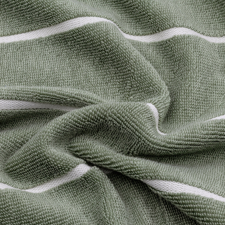 Close-up of sage green cotton towel texture with ecru binding