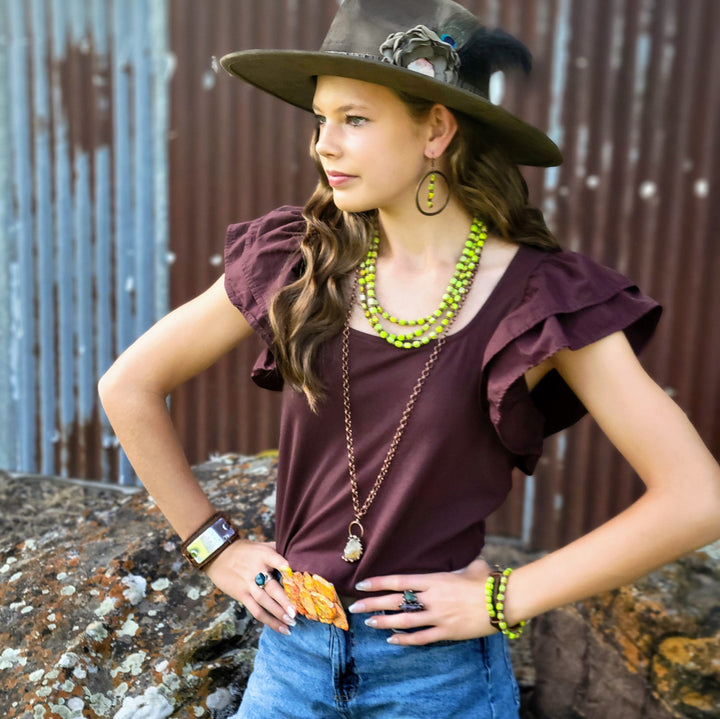 Layered lime green bead necklace worn by a woman with a copper chain
