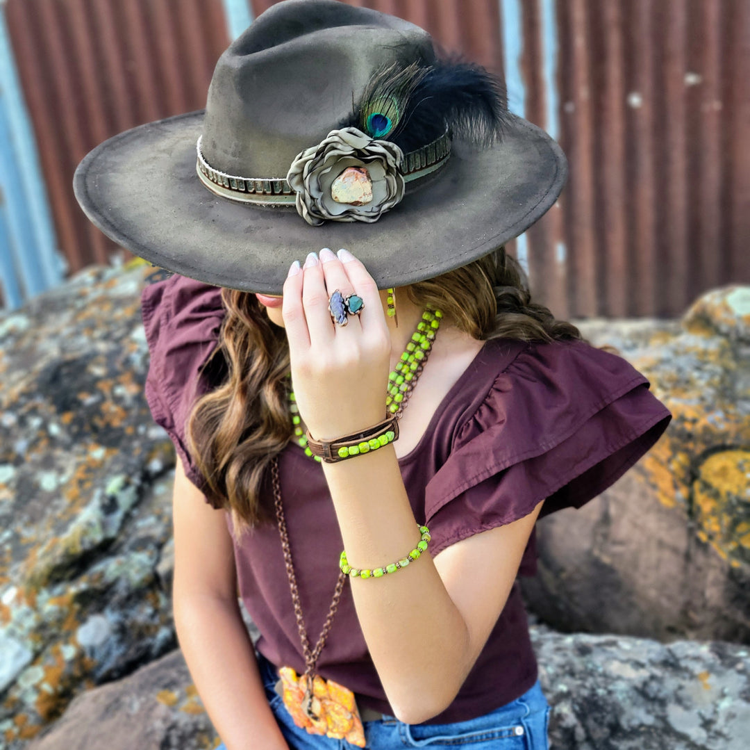 Gray-olive boho cowgirl hat with braided hatband and blue feather plume