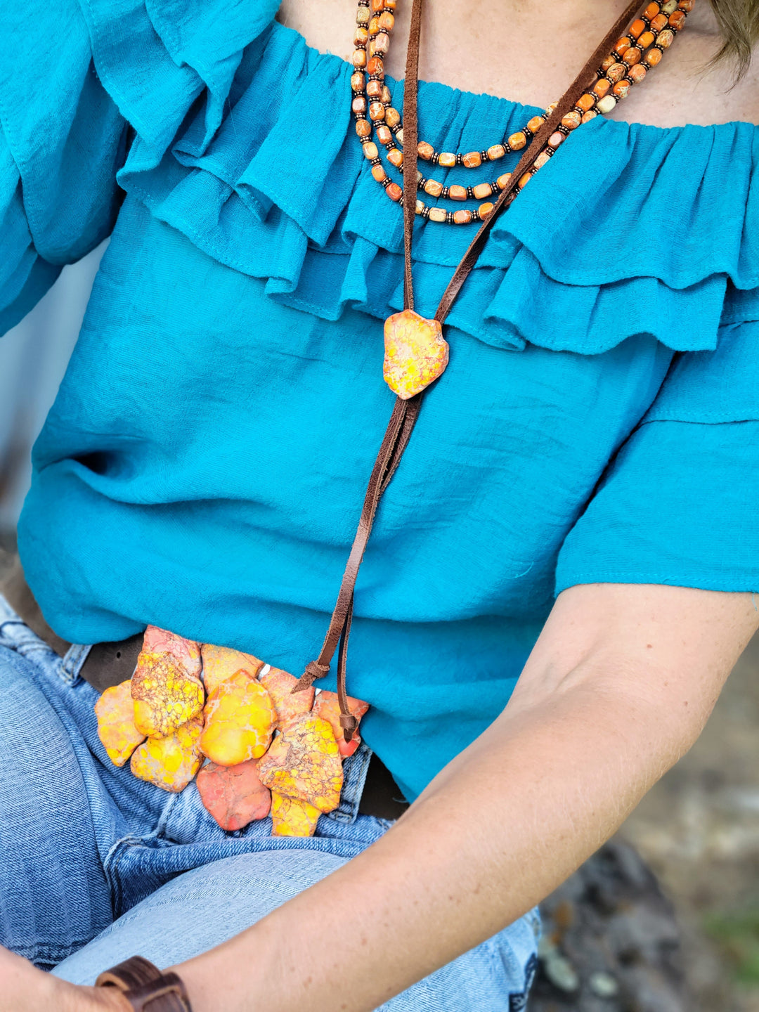 Multicolor regalite slab belt buckle detail, orange and pink stone petal cluster