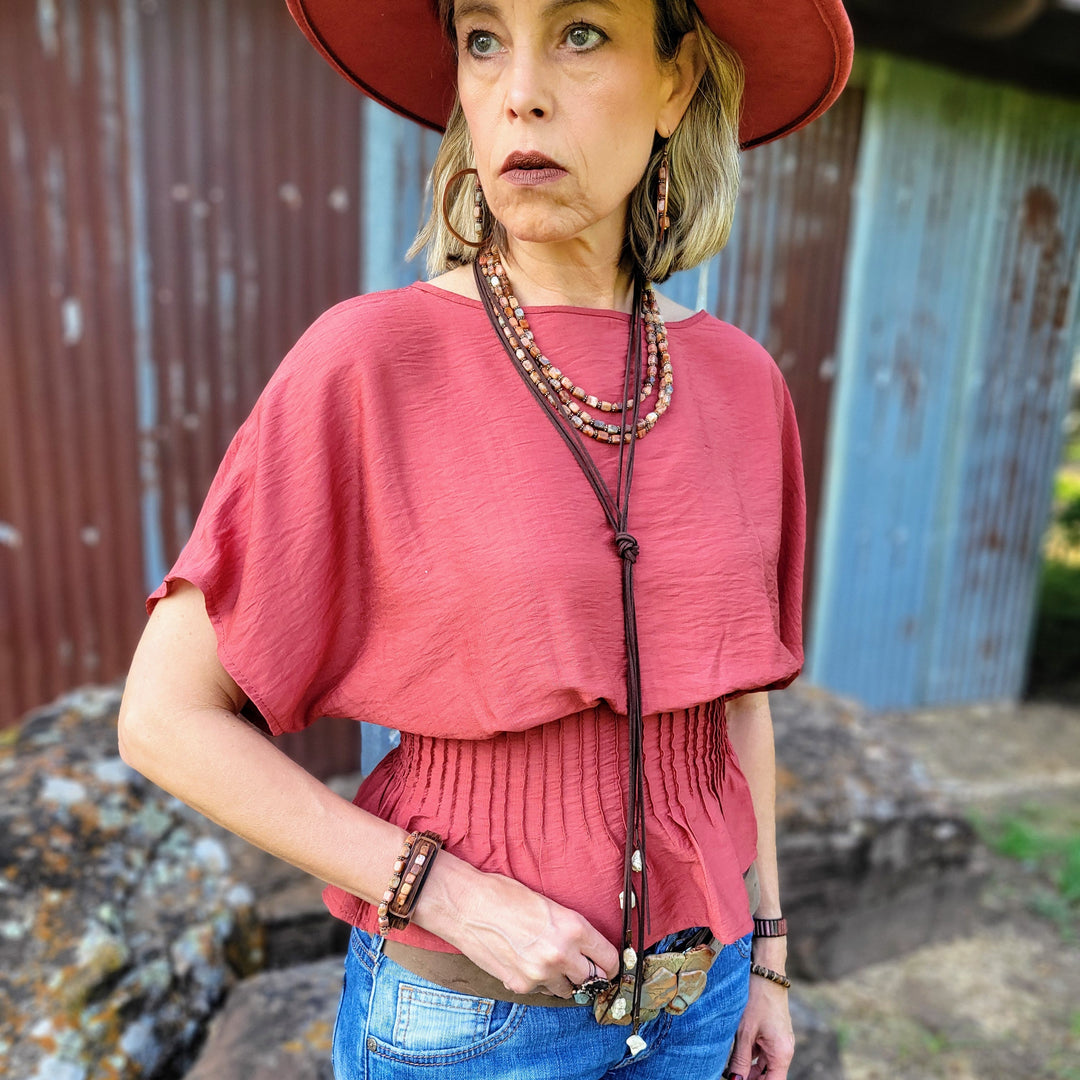 Layered beaded collar necklace on model with multi-strand rust and pink beads