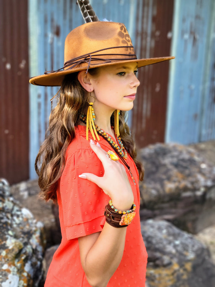 Tan felt cowgirl hat with leopard detail and white feather on the side