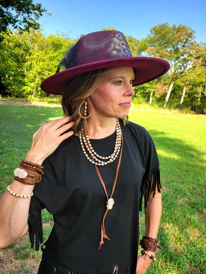 Beaded stretch bracelet in white and copper tones with dark bead spacers on wrist