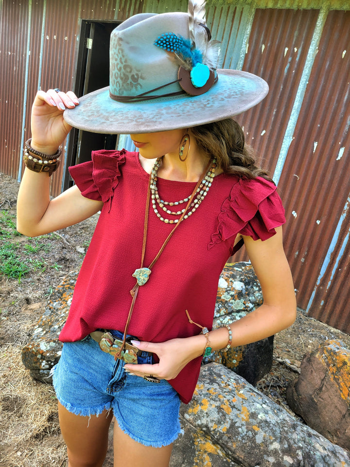 Aqua stone pendant leather lariat necklace worn with layered beads and long tassels