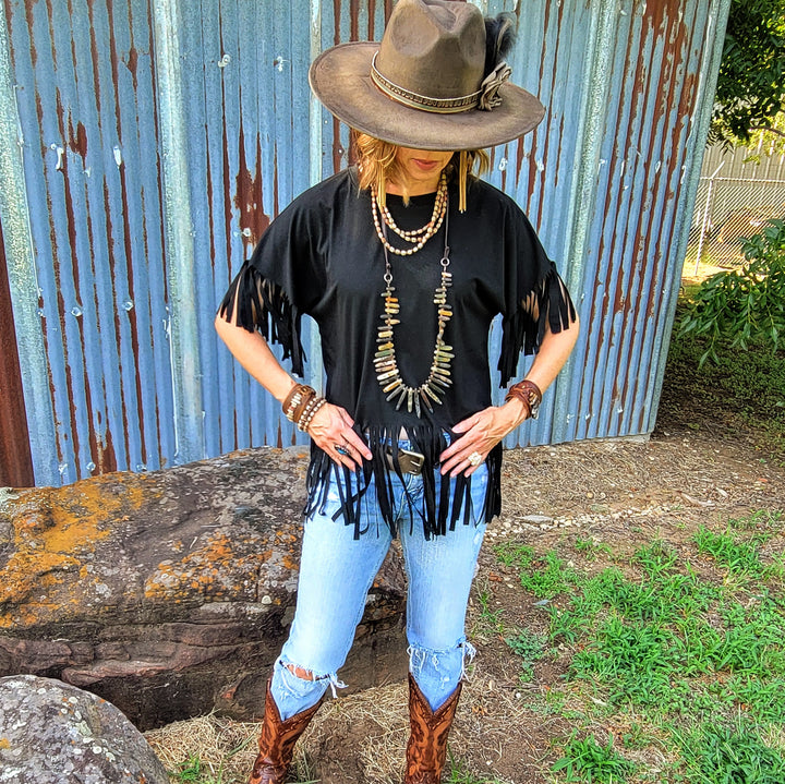 Tan felt cowgirl hat with narrow band and short feather accent