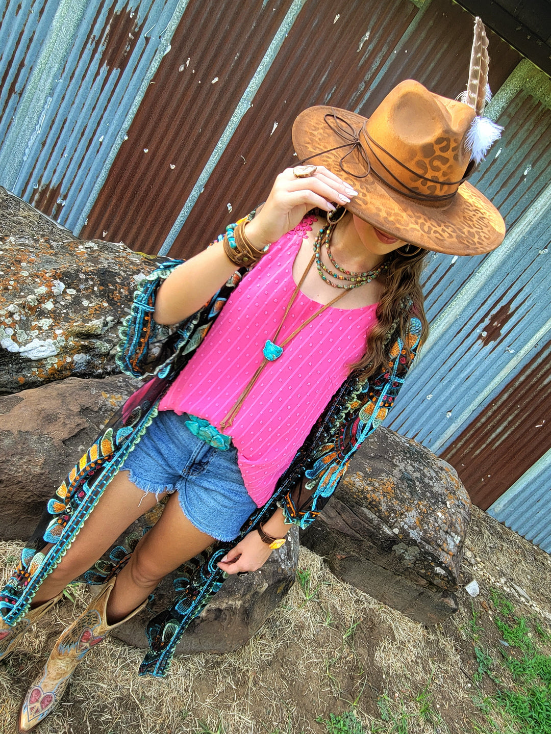 Tan leopard-pattern cowgirl hat with white feather on tan hatband