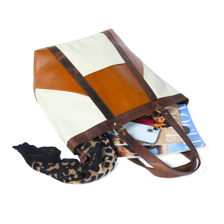 Two-tone leather tote laid open, showing interior and contents