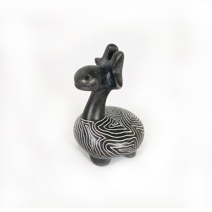 Soapstone giraffe figurine with dark body and white wavy stripe pattern, facing forward-left
