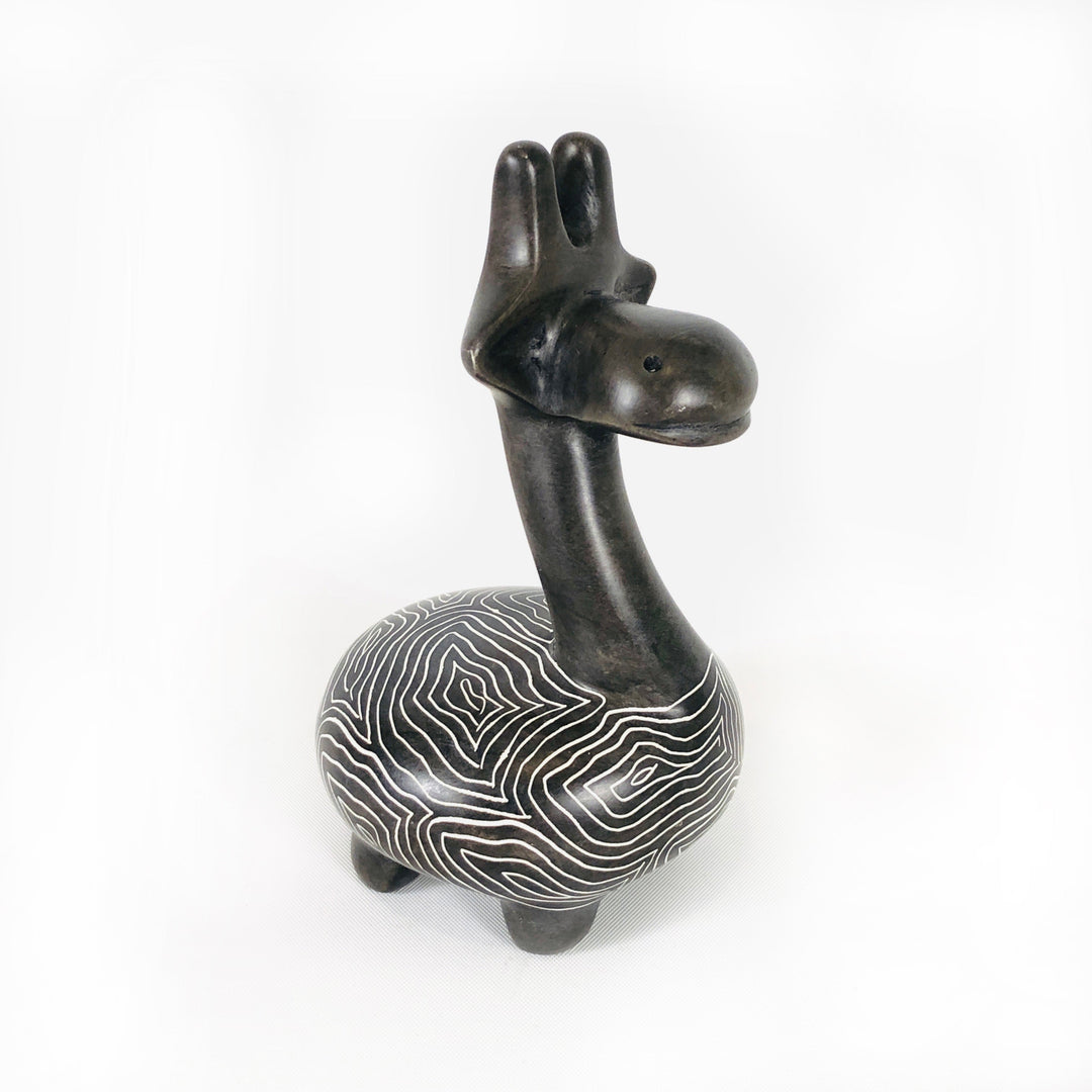 Soapstone giraffe figurine with dark neck and head and white wavy striped belly, side view