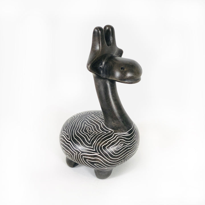 Soapstone giraffe figurine with dark neck and head and white wavy striped belly, side view