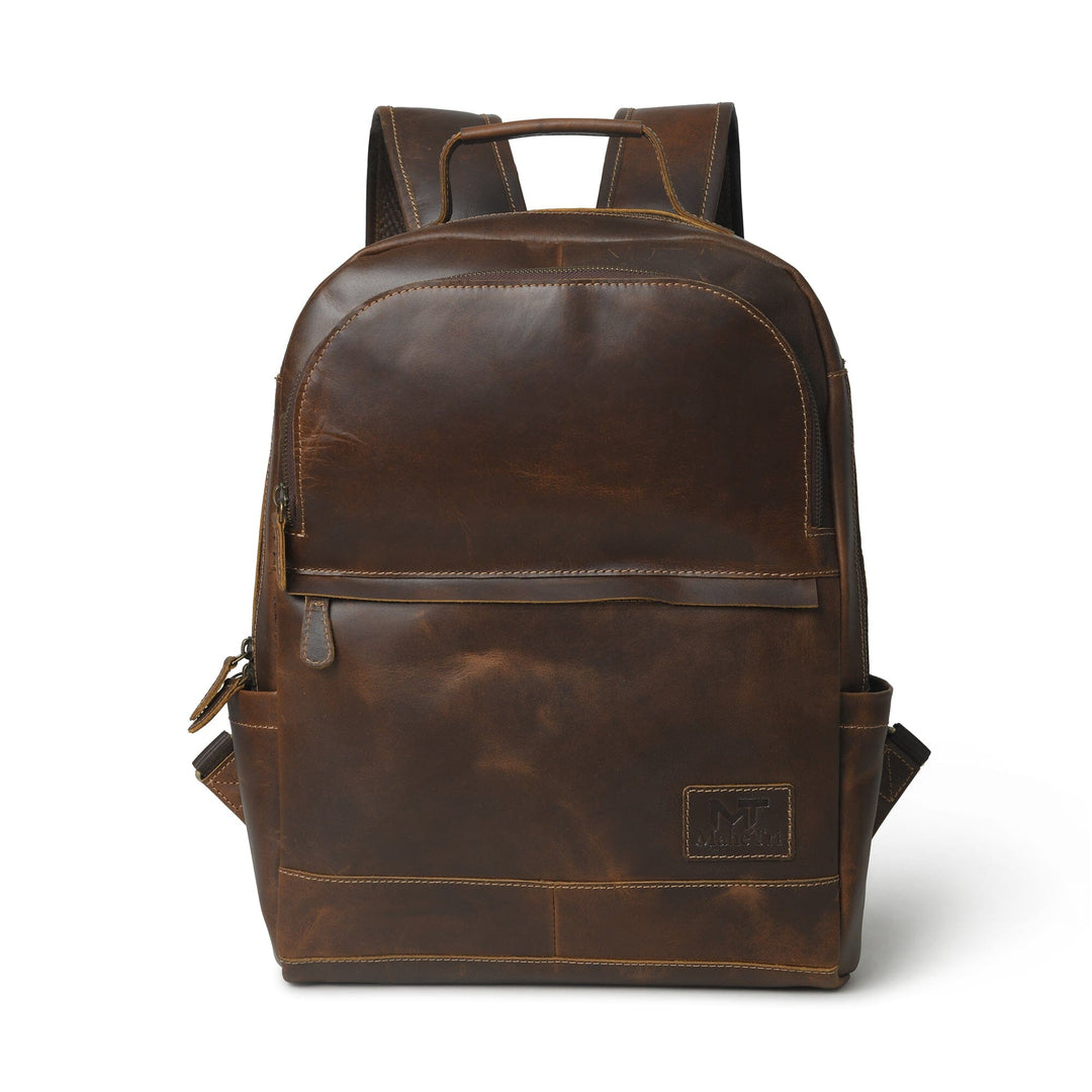 Brown buffalo leather backpack with front zipper pocket, top handle, and logo patch.