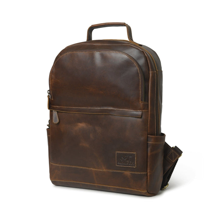 Brown buffalo leather backpack front view with front pocket zipper, top handle, and logo patch.
