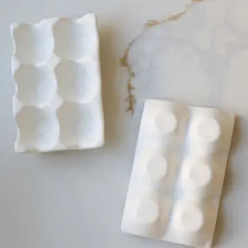 White ceramic egg tray with molded egg cup compartments, shown in two tray angles