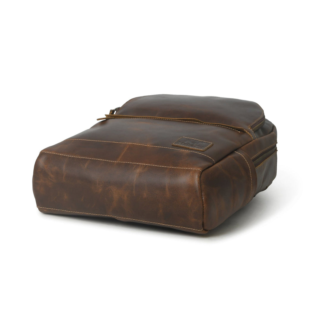 Brown buffalo leather backpack with structured base, top handle, and zipper closure.