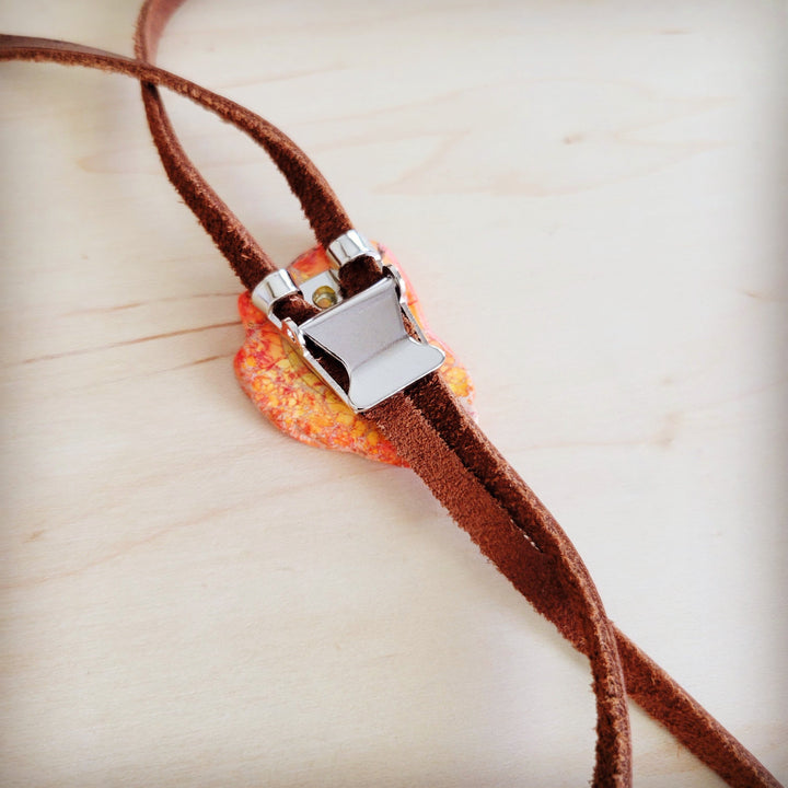 Orange Regalite slab accent with metal clasp on brown leather lariat cord