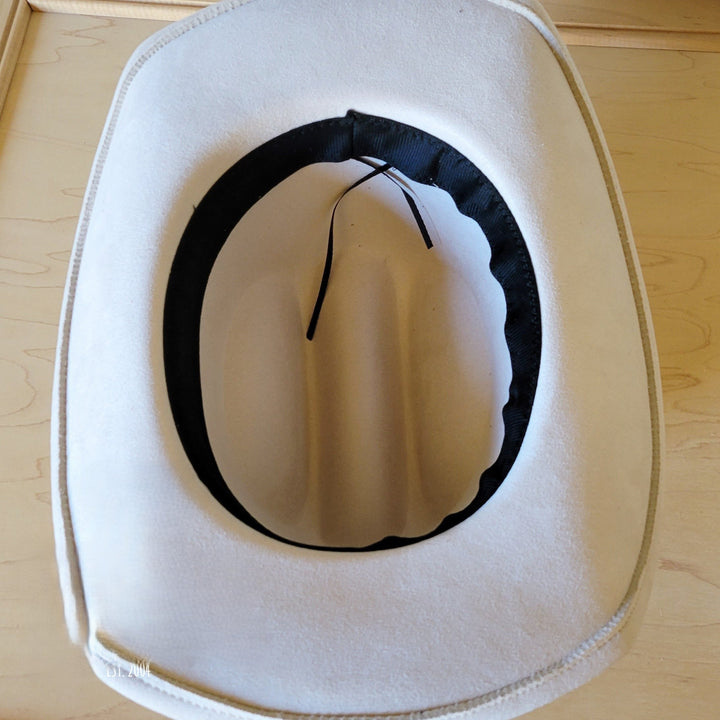White felt hat showing black inner band and tie strings