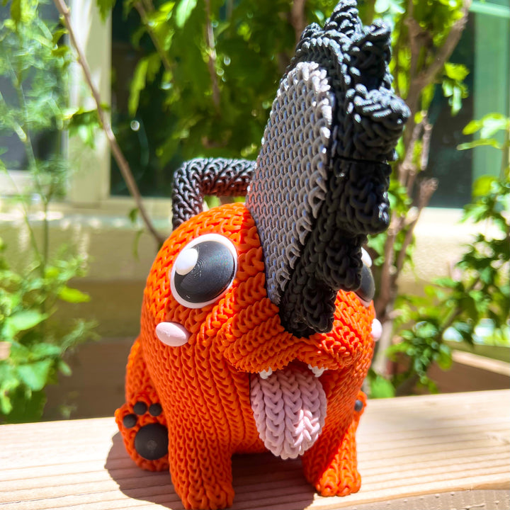 Knitted orange plush with black yarn mane, gray button eye, white muzzle patch, seated pose