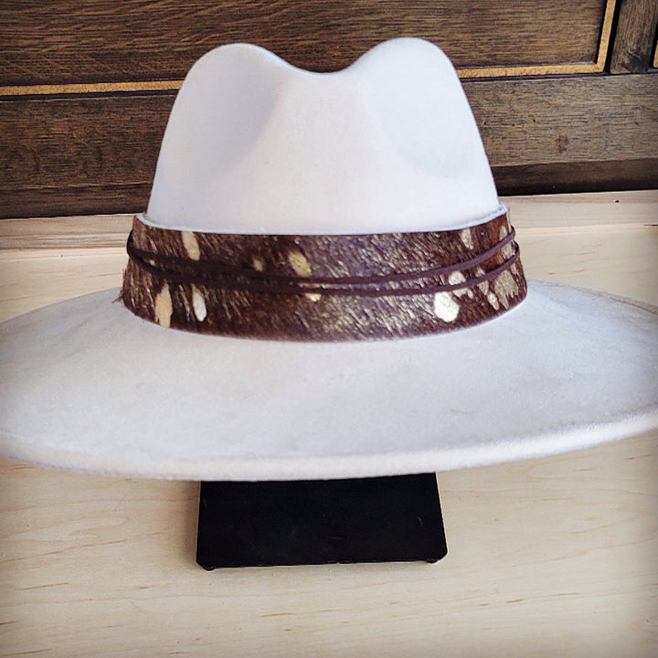 White wide-brim felt hat with dark-brown metallic patterned band and centered crown