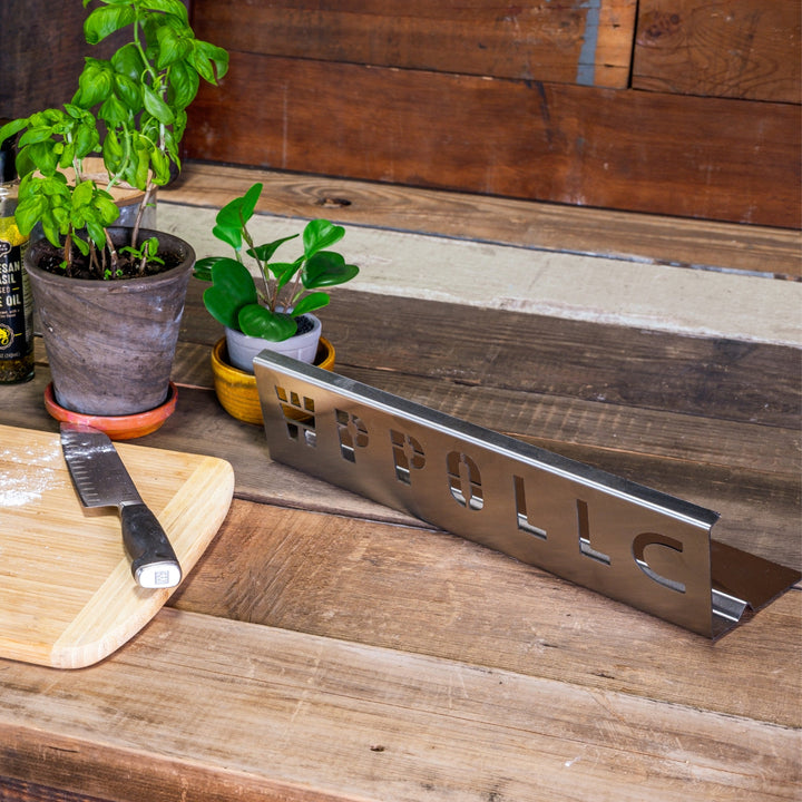 Stainless steel heat deflector with engraved lettering, lying flat on surface