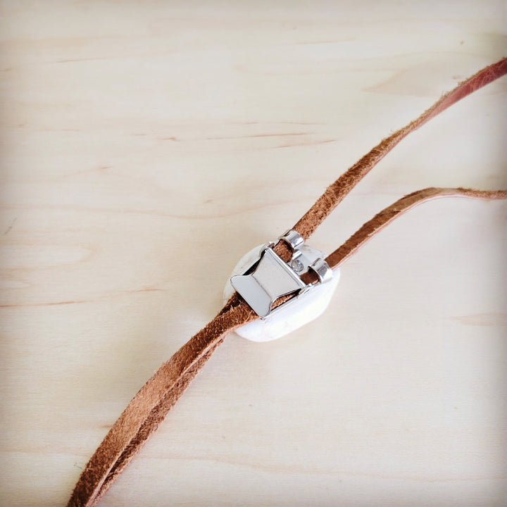 Leather lariat necklace clasp with silver-toned hardware on brown cord