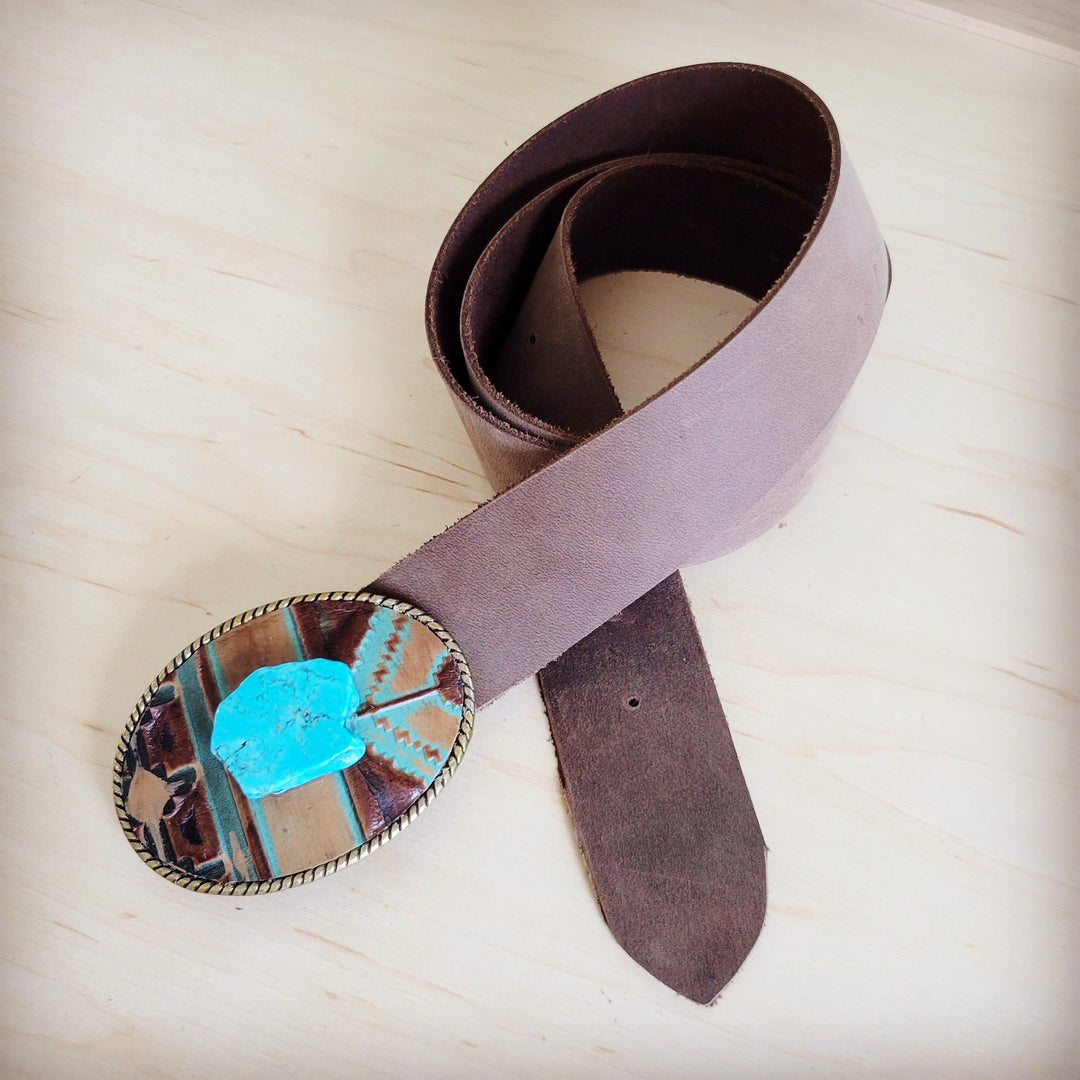 Distressed brown leather belt with blue stone buckle accent and metal roller buckle