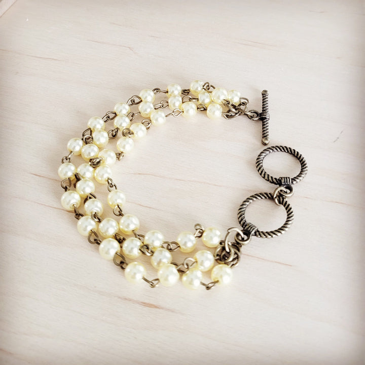 Champagne pearl triple-strand beaded bracelet with ring-drop charm and toggle clasp