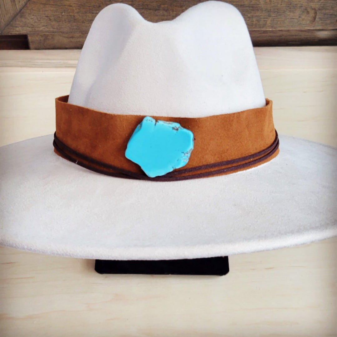 Tan suede wide hat band with turquoise leather centerpiece on white felt hat