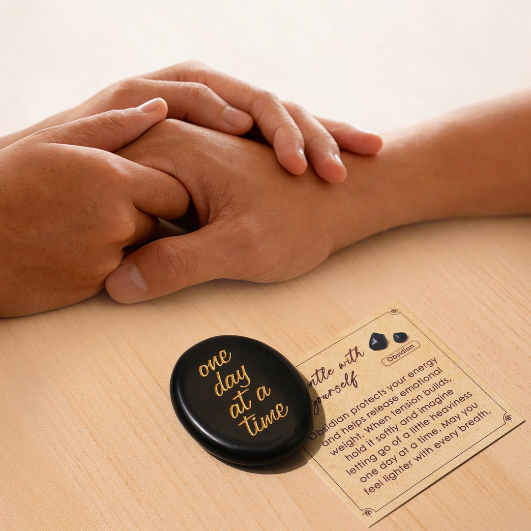 Black oval pocket crystal stone with gold “one day at a time” text