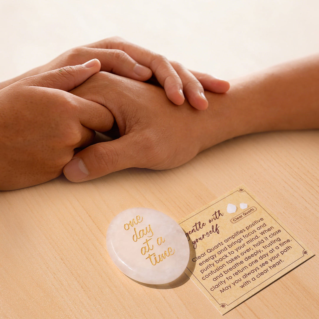 Green pocket crystal stone with gold “one day at a time” text in hand