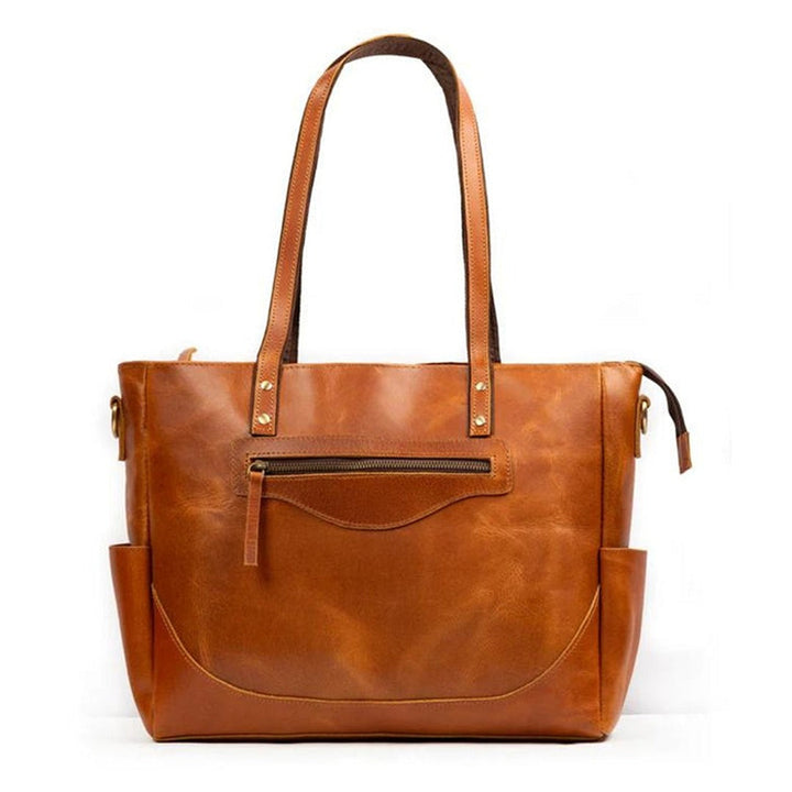 Tan leather tote bag with dual top handles, center zip pocket, and side zipper pulls