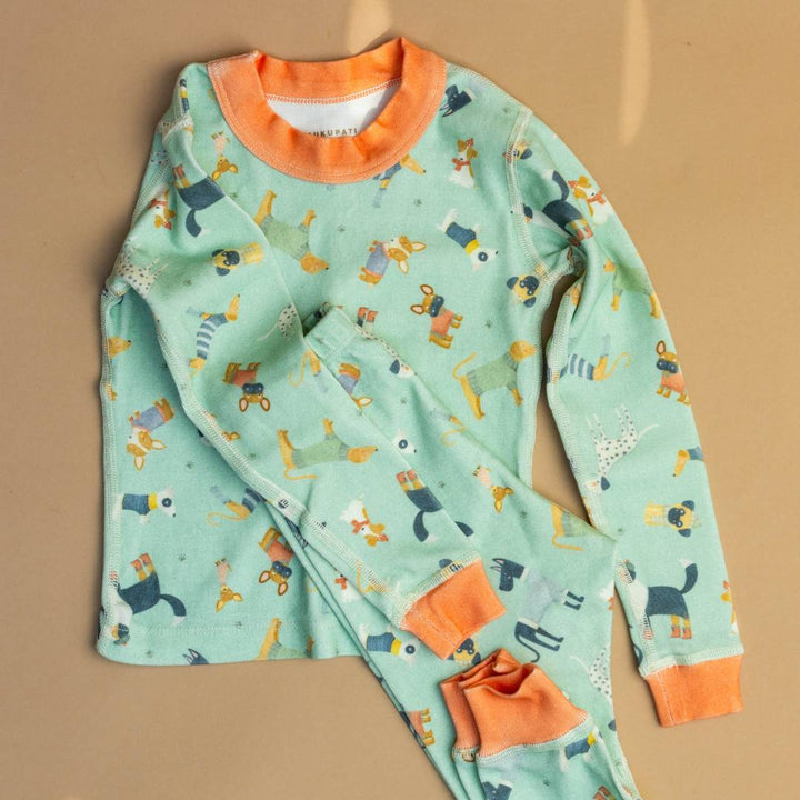 Teal pajama top and pants set with orange cuffs and scattered animal illustrations