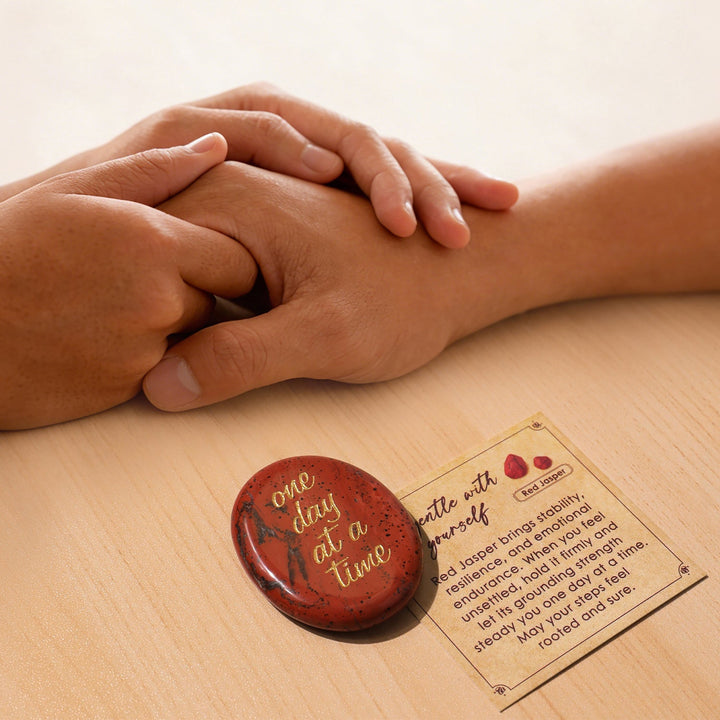 Red oval pocket crystal stone with gold “one day at a time” text