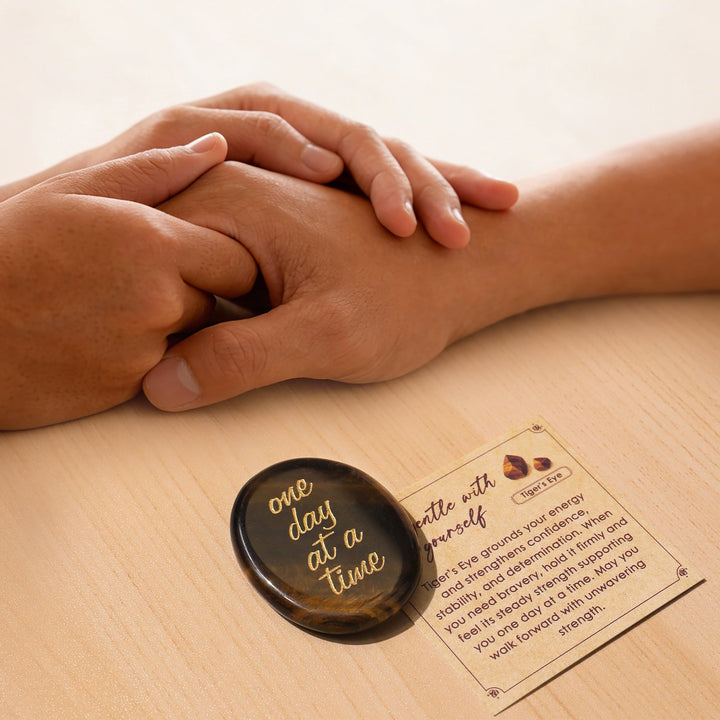 Dark brown oval pocket crystal stone with gold “one day at a time” text