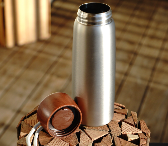 Stainless steel insulated tumbler with wooden lid open and carry loop
