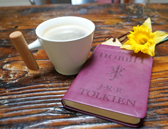 White ceramic mug with wooden handle, holding light-colored beverage