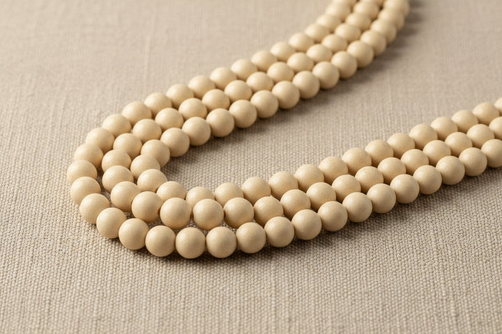 Cream round smooth agate bead strand, close-up view of rounded beads