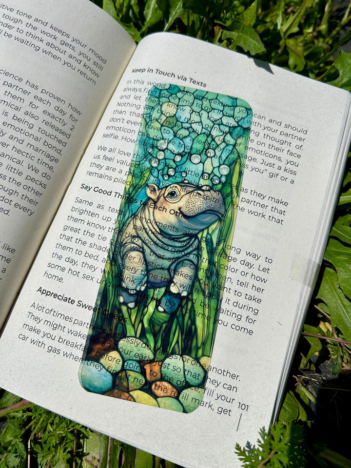 Teal hippo bookmark with cartoon face and black text on a book page