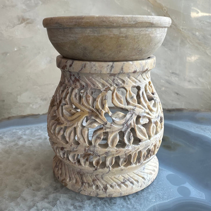 Carved soapstone essential oil burner with textured leaf relief around round opening